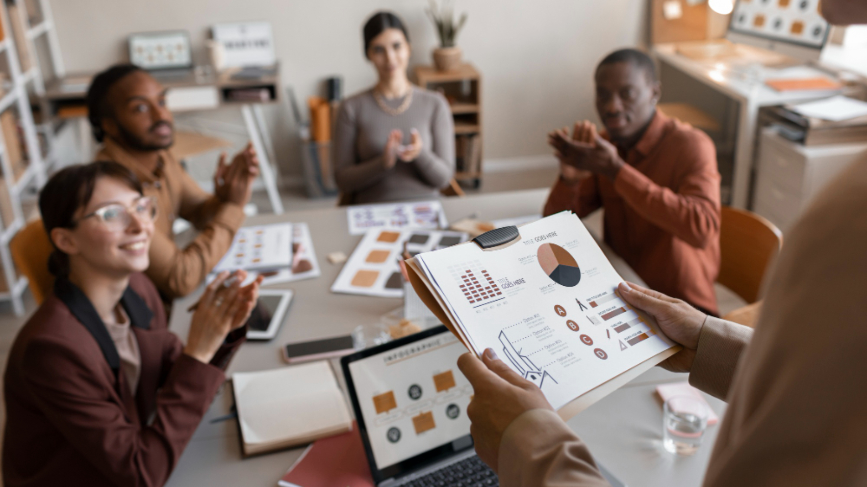 Equipe reunida analisando indicadores e relatórios de desempenho para avaliar o engajamento na comunicação interna.