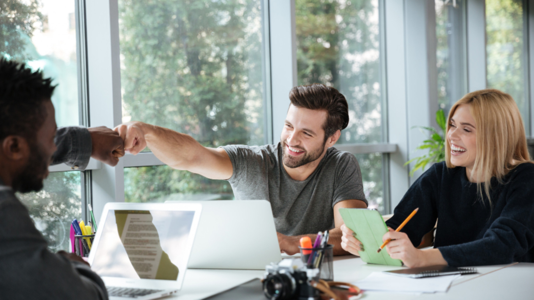 Equipe reunida em um ambiente corporativo durante o processo de onboarding, interagindo de forma colaborativa para representar o suporte oferecido pelo fornecedor de comunicação interna.