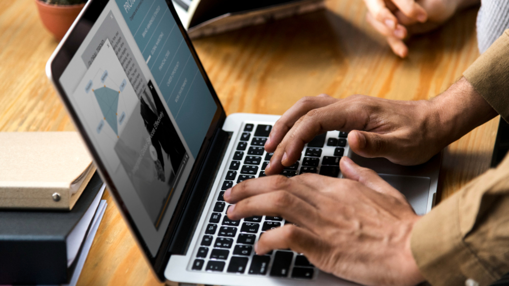 Profissional utilizando um notebook para acessar uma plataforma corporativa, avaliando recursos de uma intranet dedicada em comparação com o SharePoint nativo.