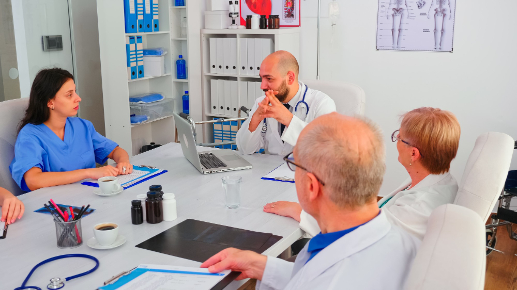Equipe médica reunida em uma sala de reuniões no hospital discutindo processos e estratégias de comunicação interna para integração entre profissionais de saúde.